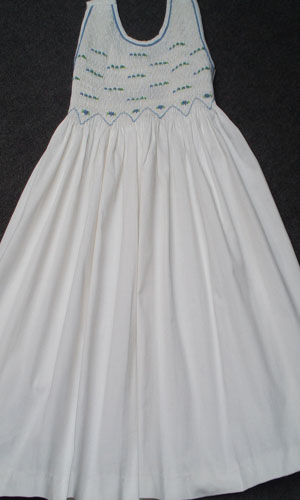 Robe blanche à smocks 8 ans , peut être robe de communion , en piqué de coton , petite ceinture à nouer derrière.